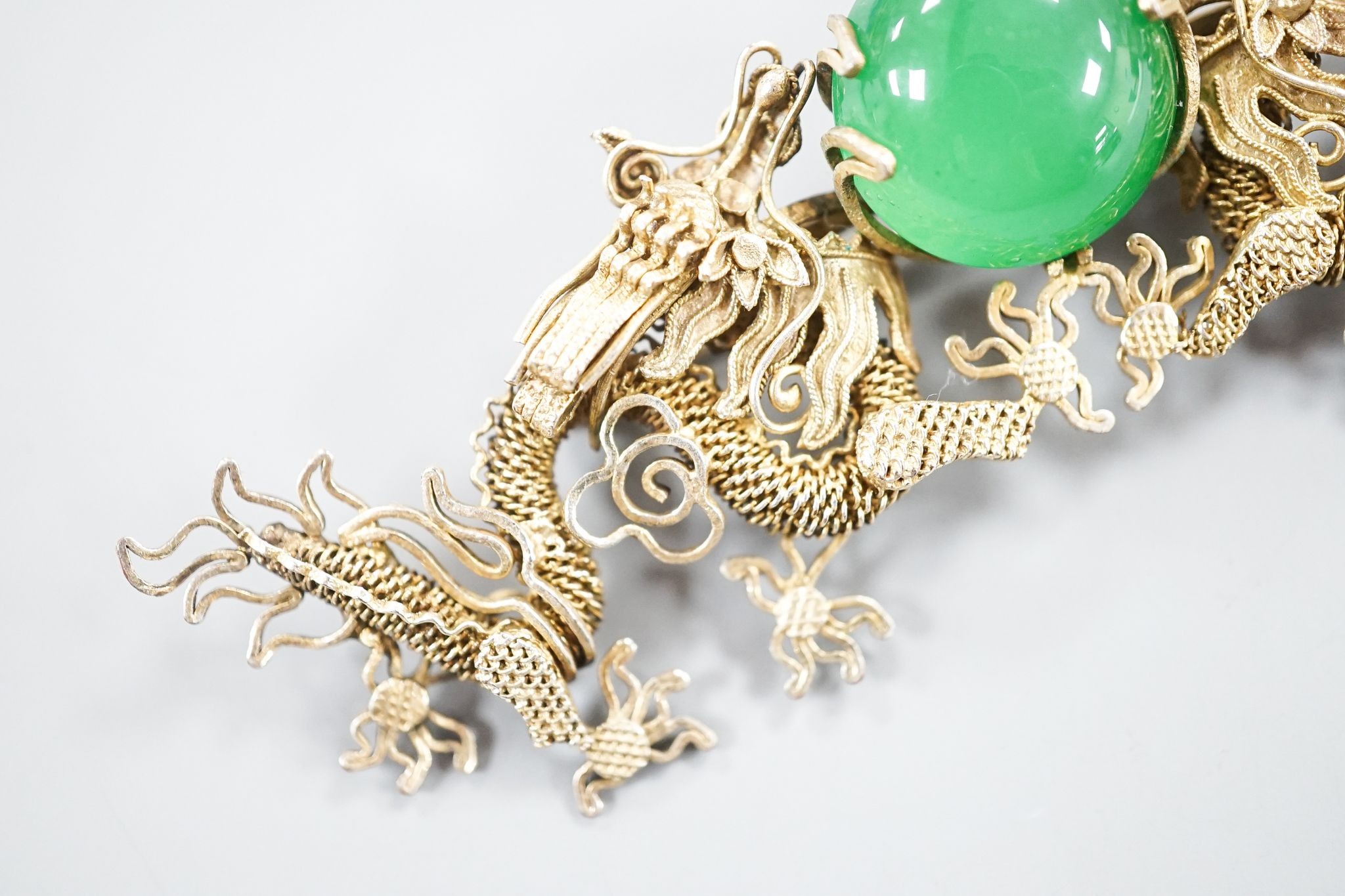A Chinese gilt white metal and green cabochon set dragon brooch, 89mm.